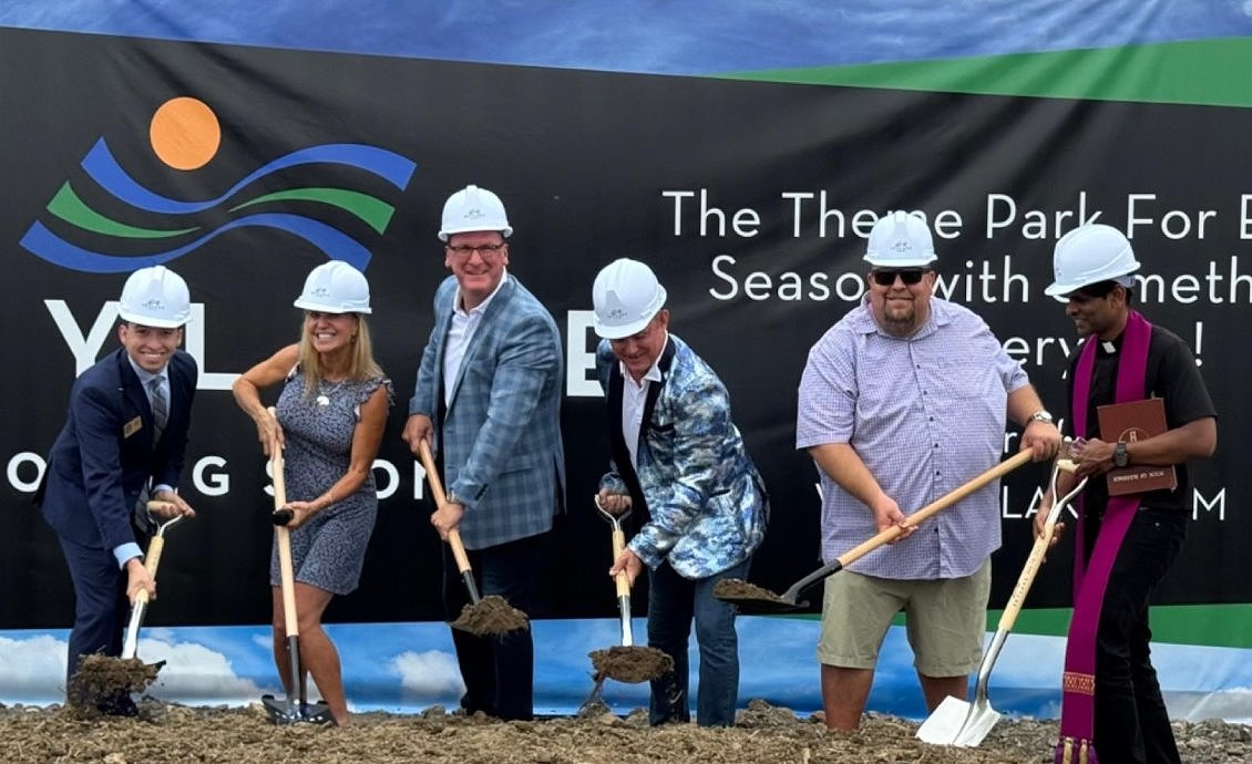 Six people wearing hard hats participate in the groundbreaking ceremony for the SkyLake Theme Park near Westfield, Indiana